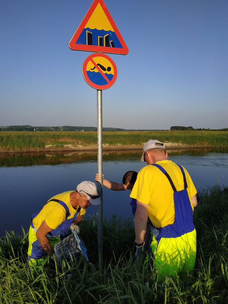 pracownicy MPGKiM montują znak "Zakaz pływania"